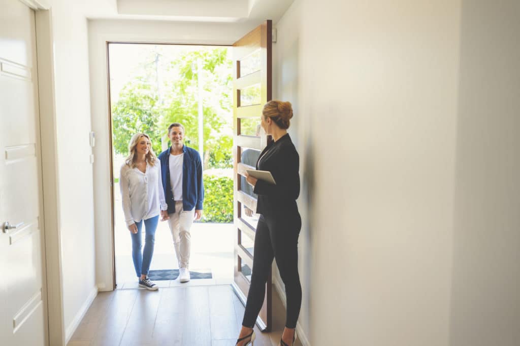 Real estate agent showing a young couple a new house.