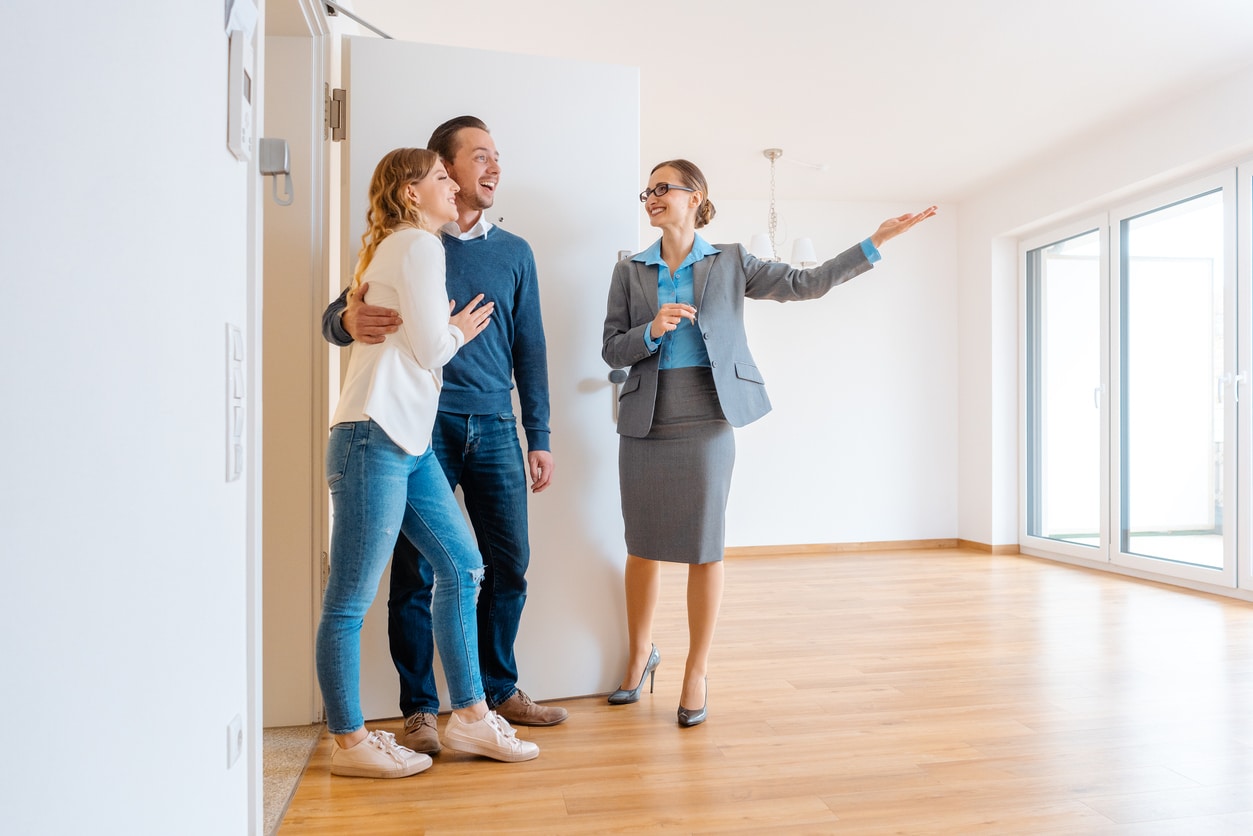 Realtor showing house to a young couple