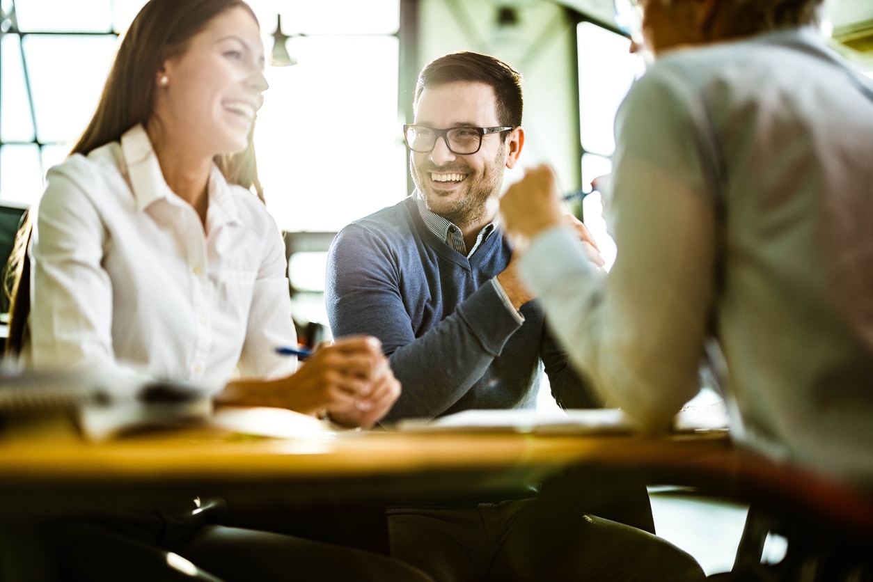 Happy couple talking to their insurance agent on a meeting in the office.